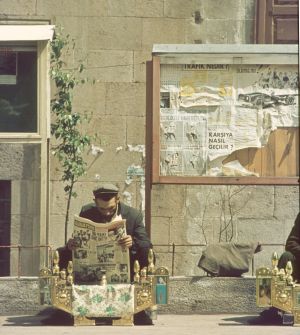Shoe-shine man reading about Appollo 11